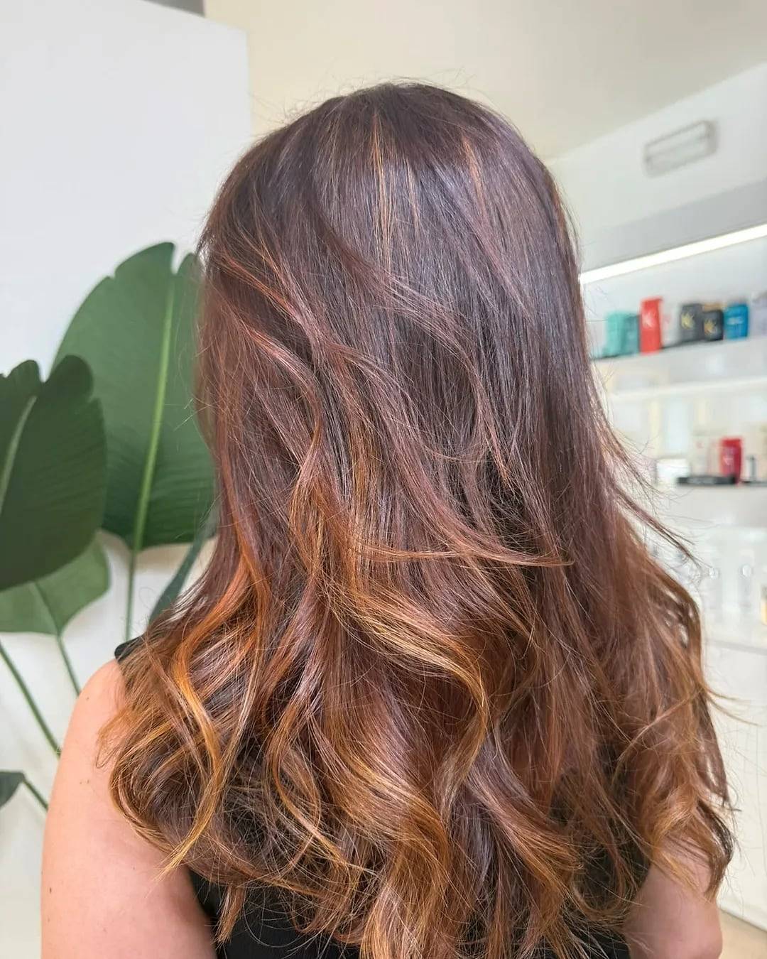 Melena larga con color castaño y reflejos cobrizos, ondas suaves, hecha en Kriado Studio